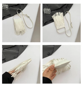 Detailed close-up of white tassel crossbody phone bag with lychee texture and slim strap
