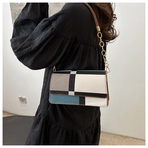 Detail of color-block geometric shoulder bag with matte leather and gold chain strap