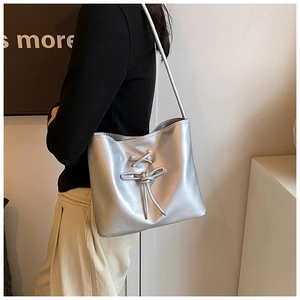 Close-up of silver metallic ballet-style shoulder bag with stylish bow drawstring detail