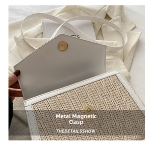 Detail view of woven straw shoulder bag with white PU trim and gold magnetic buckle