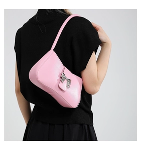 Detailansicht der rosa glänzenden Schultertasche mit dekorativer silberner Schleife