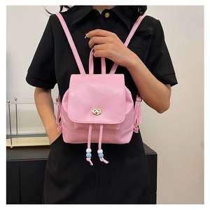 Mini pink leather backpack with metallic turn-lock and beaded drawstring on a model