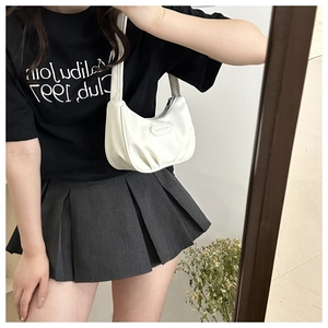 Close-up of white ruched leather crescent underarm bag with brand logo in mirror selfie