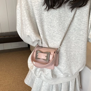 Pink mini crossbody bag with a large metallic square buckle and chic chain strap