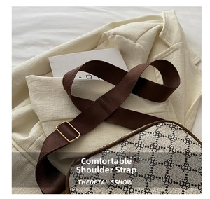Détail de la large bandoulière réglable en nylon avec boucle dorée sur le sac à bandoulière fleuri