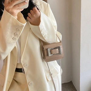 Chic khaki mini chain square bag with oversized silver buckle on beige blazer