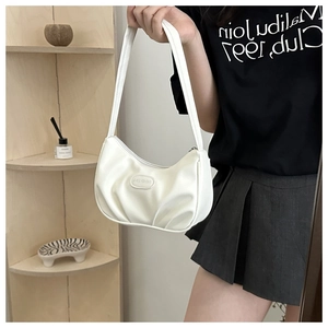 Detail of white pleated shoulder bag with oval logo plaque and stylish ruched texture