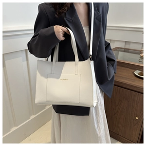 Chic beige PU leather tote bag detail with logo slot and adjustable shoulder strap