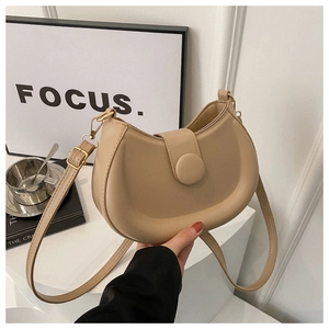 Detailed view of apricot crescent bag with matte finish and gold-tone hardware