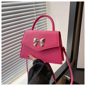 Detail of hot pink square handbag with silver bow buckle and smooth PU leather texture