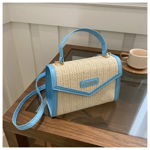 Détail du sac à bandoulière en paille avec garniture en similicuir bleu ciel et poignée