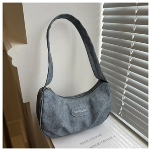 Detail of greyish-blue canvas hobo bag with Fashion & Bag text and oval stitched patch