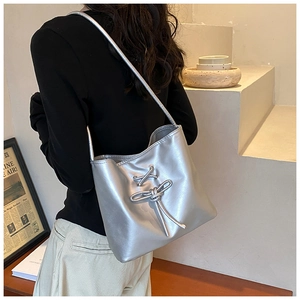 Silver metallic shoulder bag with bow detail shown on model for size and fit