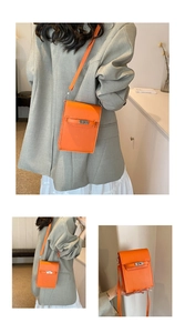 Detail of orange lychee leather cell phone bag featuring silver metal buckle and strap