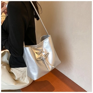 Silver PU leather shoulder bag with cross lace detail and fringe shown on model