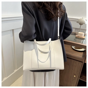 Detailed view of white chic tote bag with front pocket and adjustable shoulder strap