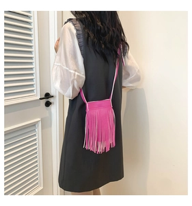 Rear view of a model wearing the rose red fringe crossbody bag with long tassels