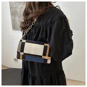 Detailed view of geometric patchwork shoulder bag with chain strap on model