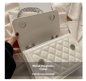 Detail of white quilted leather flap bag showing two silver magnetic snap closures