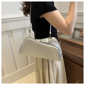 Close-up of trapezoid silver shoulder bag with gold hardware and FASHION & BAGS logo