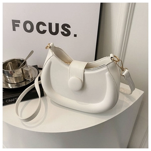 Macro detail of white puffy crossbody bag with round buckle on minimalist stage