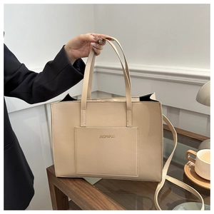 Detail of beige tote bag with long handles and JINGPINPIJU text in a lifestyle setting