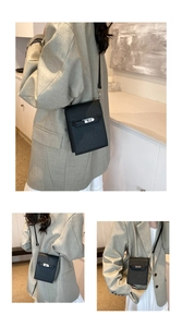 Close-up of black vertical mini bag with litchi grain texture and metal turn-lock