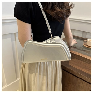 Silver irregular geometric shoulder bag with metallic texture shown on model back view