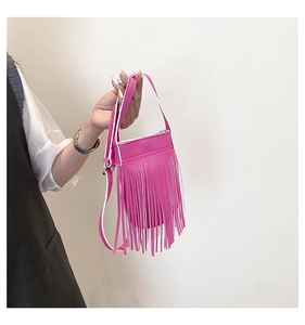 Detail of rose pink tassel crossbody bag with premium lychee grain leather texture