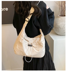 Detail of cream nylon crossbody bag with adjustable wide strap and drawstring decor