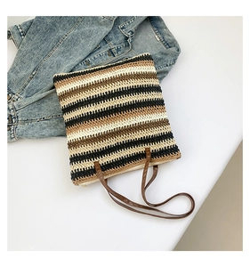 Detail of multi-color striped straw tote bag texture with brown faux leather straps