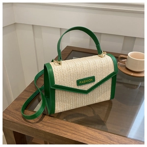 Détail du sac en paille beige avec garniture en cuir vert et plaque dorée FASHION