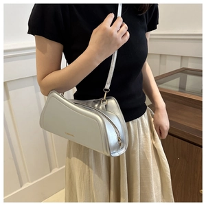 Detail of silver metallic crossbody bag with golden zipper and fashion logo on leather