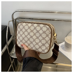 Détail du petit sac bandoulière monogramme vintage avec garniture en cuir brun et dorures