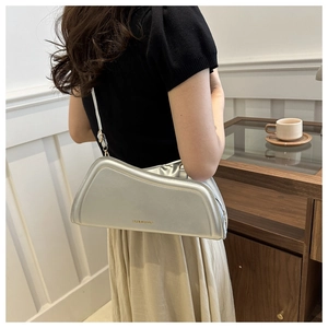 Chic silver asymmetric hobo bag styled on shoulder in a warm lifestyle setting