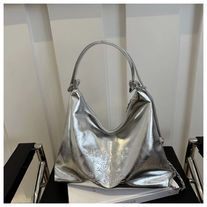 Detailed shot of silver faux leather tote bag with embossed letters and metal chain strap