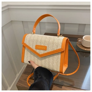 Détail du sac bandoulière en paille orange vif avec paillettes et poignée supérieure