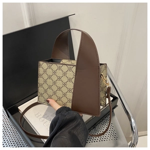 Detail der Vintage Box-Tasche mit Kleeblattmuster, Lederbesatz und Goldbeschlägen