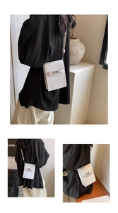 Vertical white PU leather mobile phone crossbody bag with silver buckle detail on model