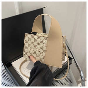 Detail der eleganten Handtasche in Beige und Braun mit Monogramm-Muster und Kleemotiven