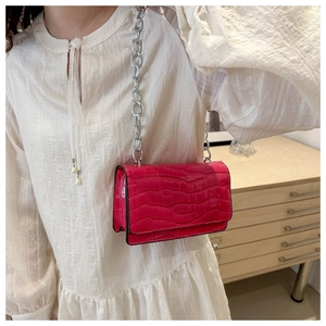Detail of hot pink crocodile embossed small crossbody bag with silver chain strap