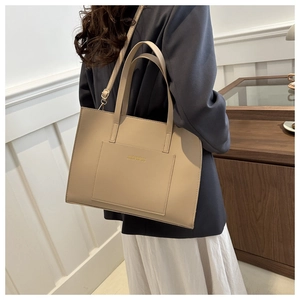 Beige tote bag with adjustable shoulder strap shown in a lifestyle interior setting