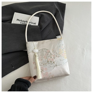 Vue détaillée du sac seau en satin de soie avec motifs floraux et pampille blanche longue
