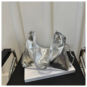 Close-up of silver hobo bag featuring embossed lettering and stylish metal chain
