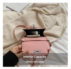 Internal view of pink mini crossbody bag holding cosmetics on beige knit blanket