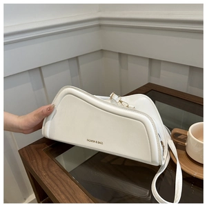 Detailed view of off-white asymmetric PU leather shoulder bag with gold hardware detail