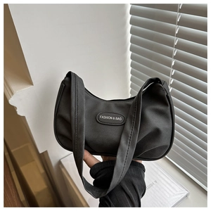 Detail of black nylon crescent shoulder bag with pleated texture and fashion label