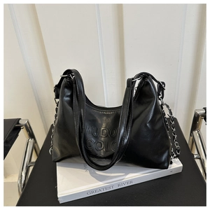 Detail of black leather hobo bag featuring embossed MUDO COLOR text and silver chain