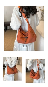 Detail of vibrant orange crossbody tote bag with drawstring pleated design and wide strap