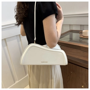 Detail of white geometric wave shoulder bag showing the unique modern artistic silhouette